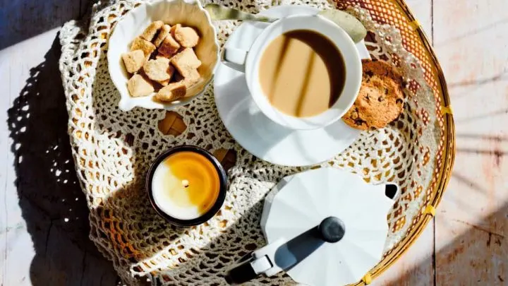 A cup of coffee along with cookies and snacks.