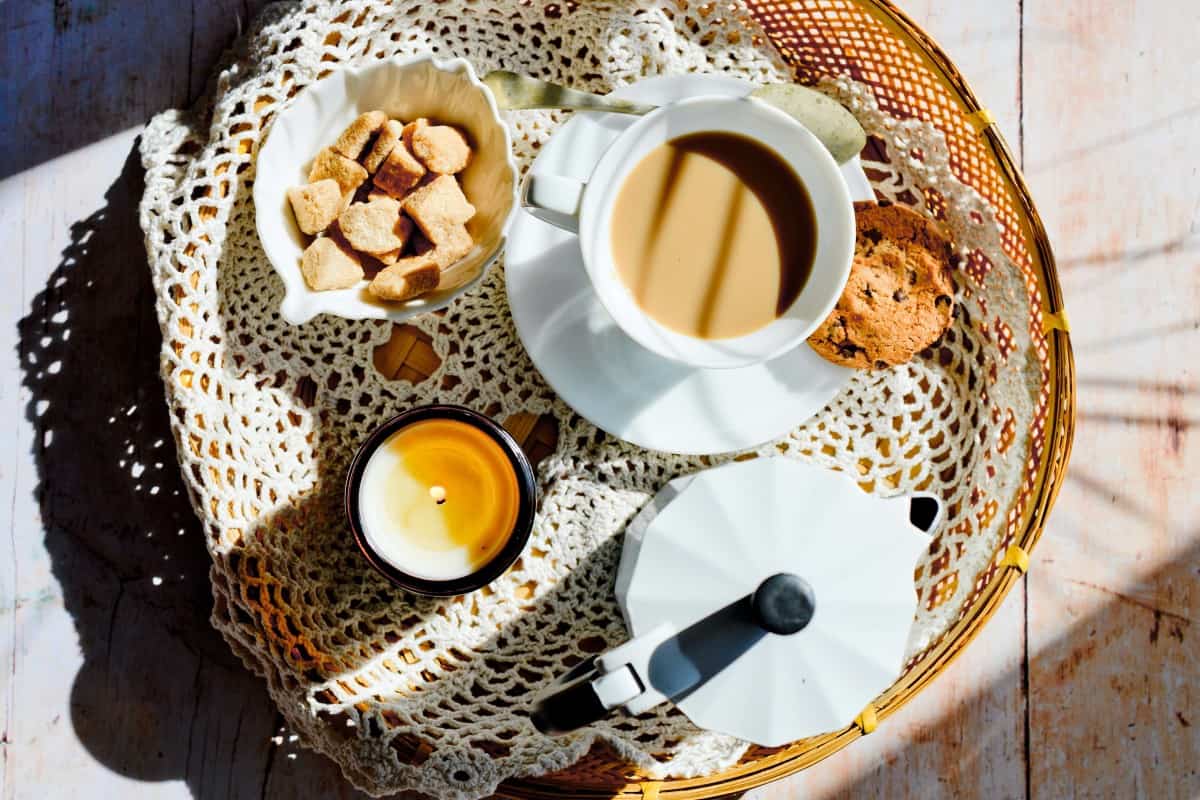 A cup of coffee along with cookies and snacks.