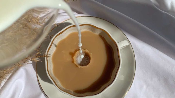 Pouring cream in coffee