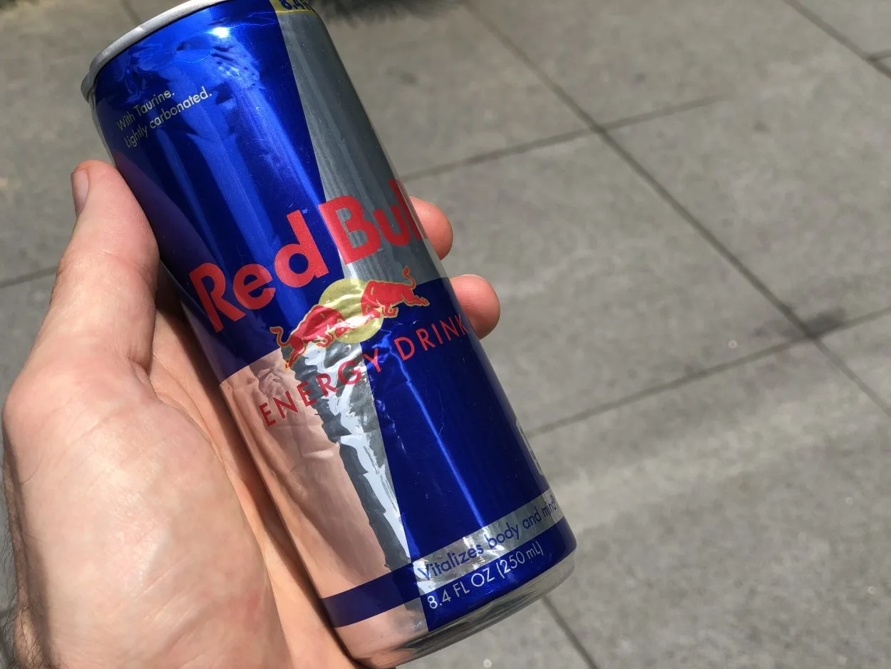 a can of red bull in hand