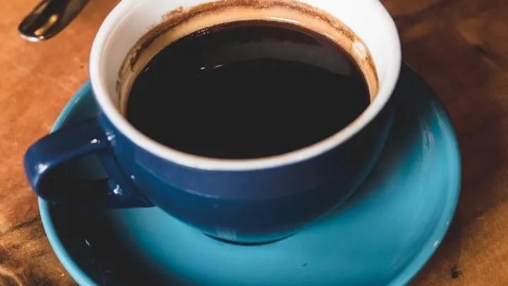 Black coffee in blue ceramic cup.