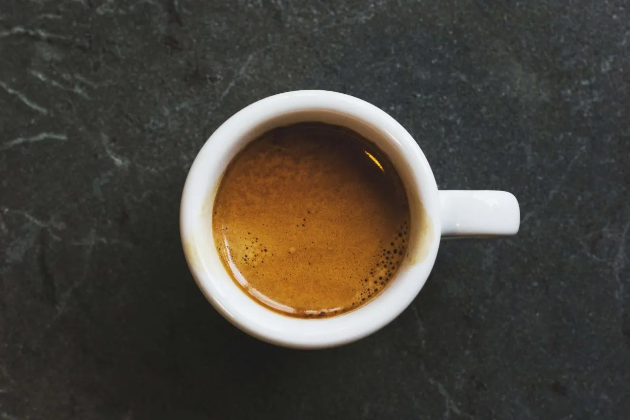 Top view of an espresso shot in a white shot mug.