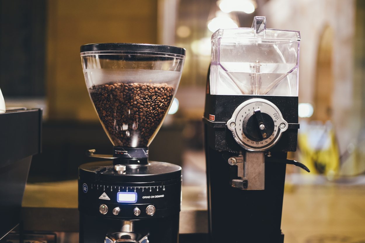 A front view of a black coffee maker with a grinder.