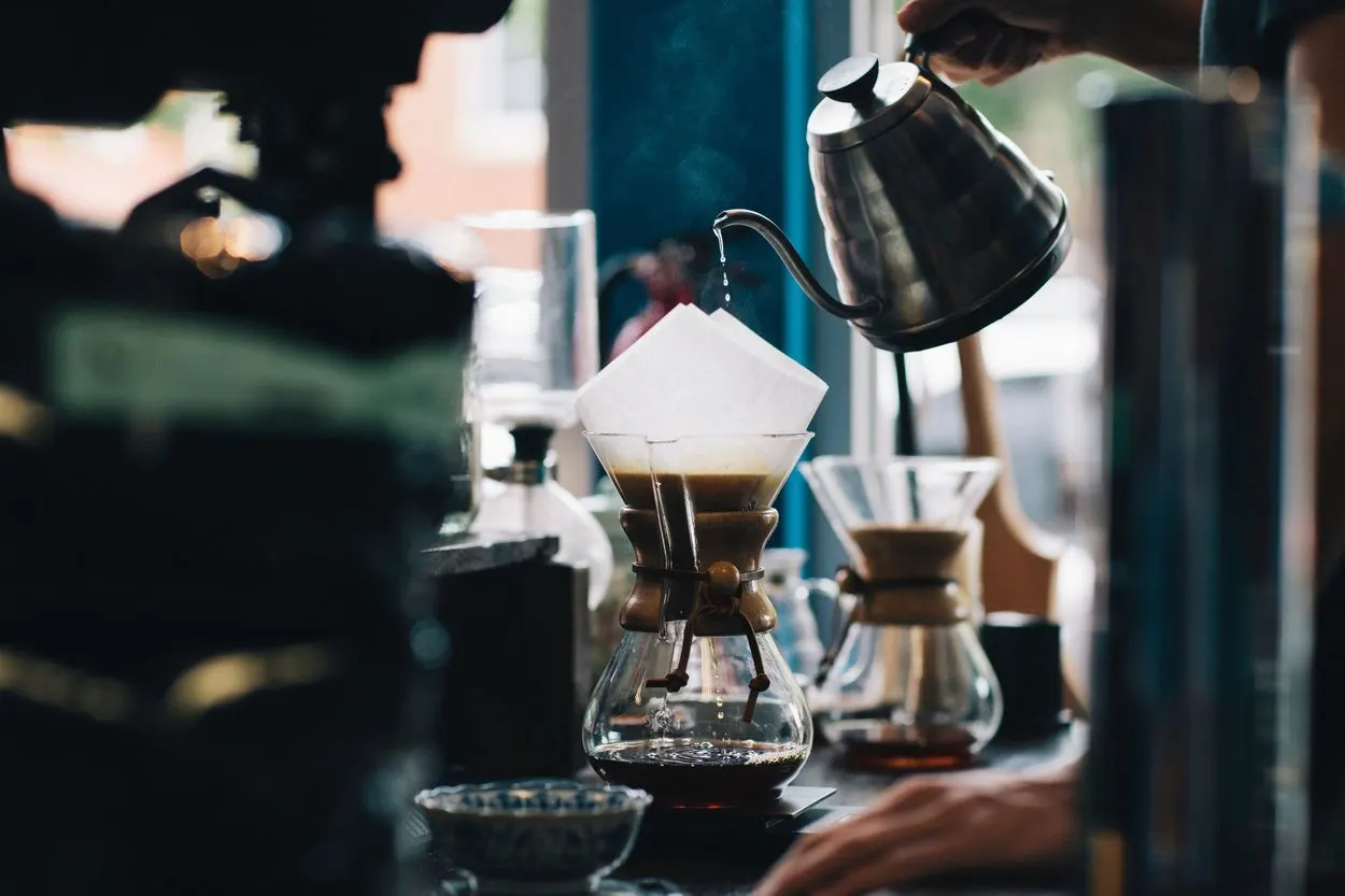 a barista is brewing coffee using the drip brew method.