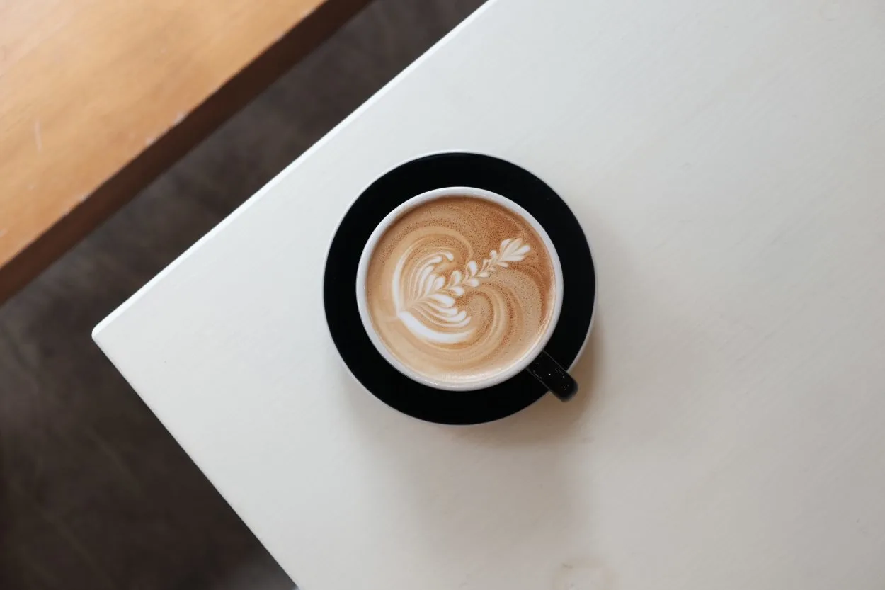 a latte on a black saucer