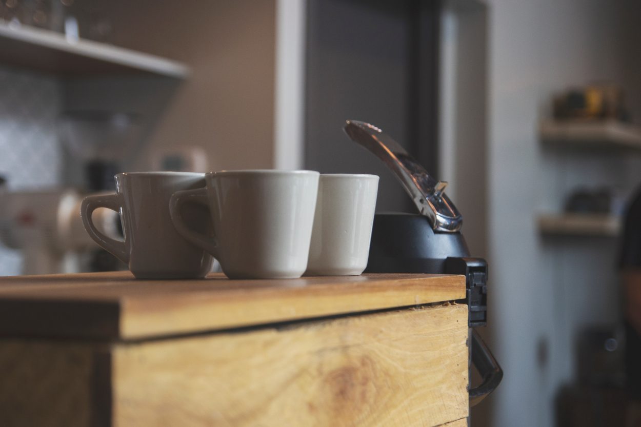three coffee mugs sitting on a wooden counter