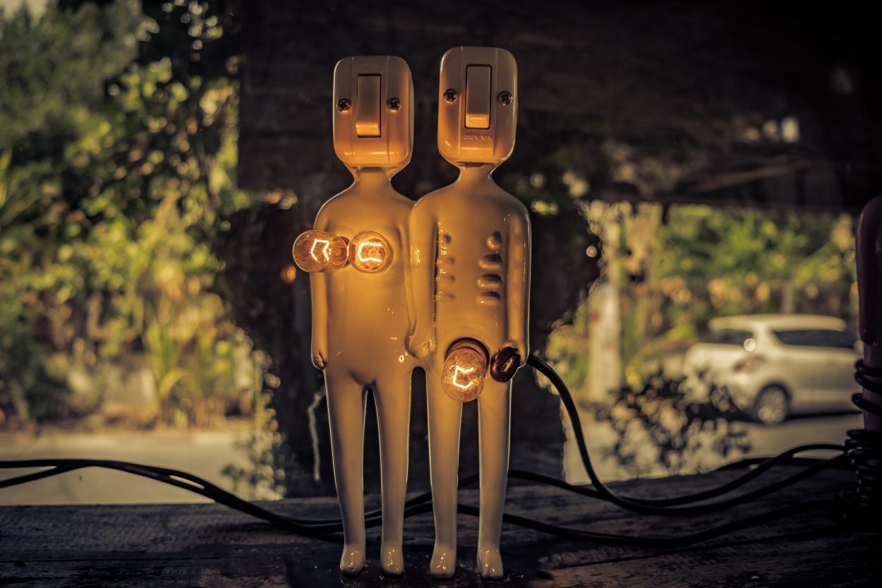 two dolls with light bulbs as their genitals