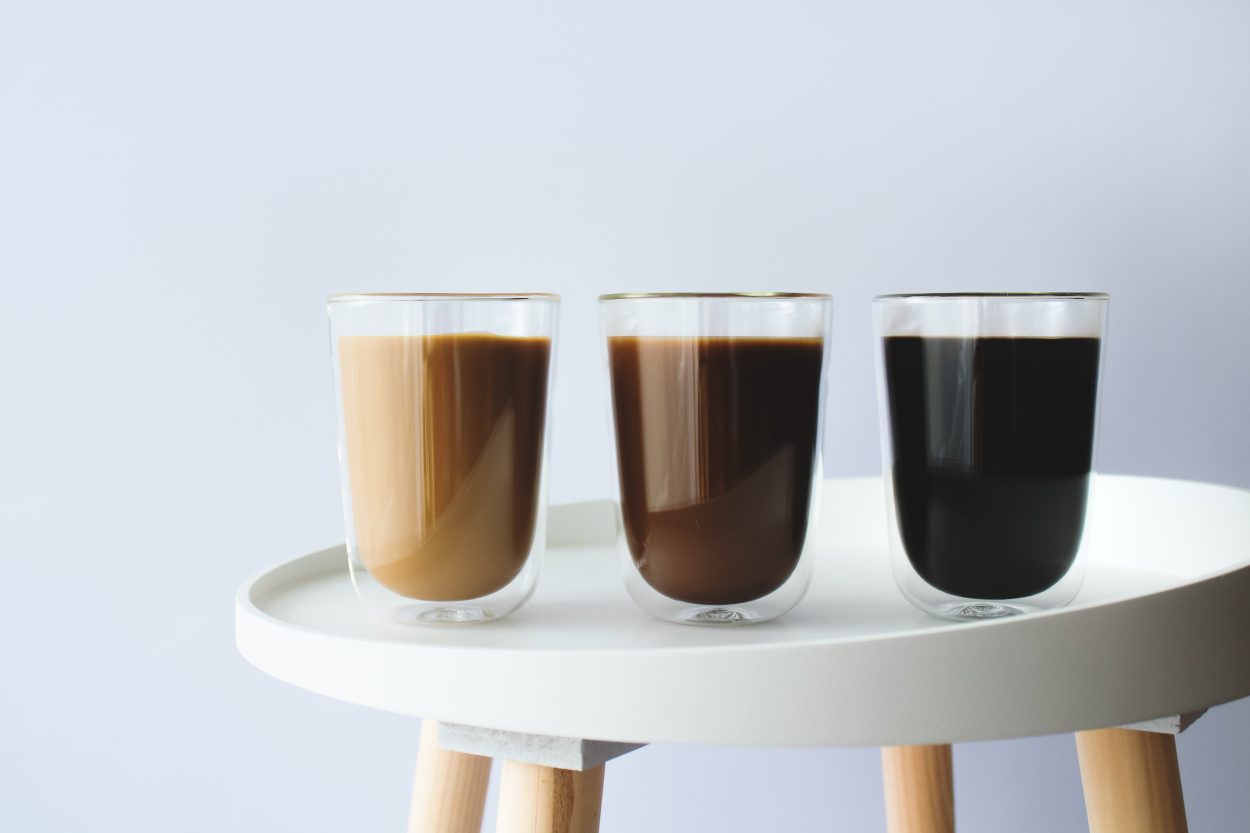 three glasses of coffee lined up on a chair