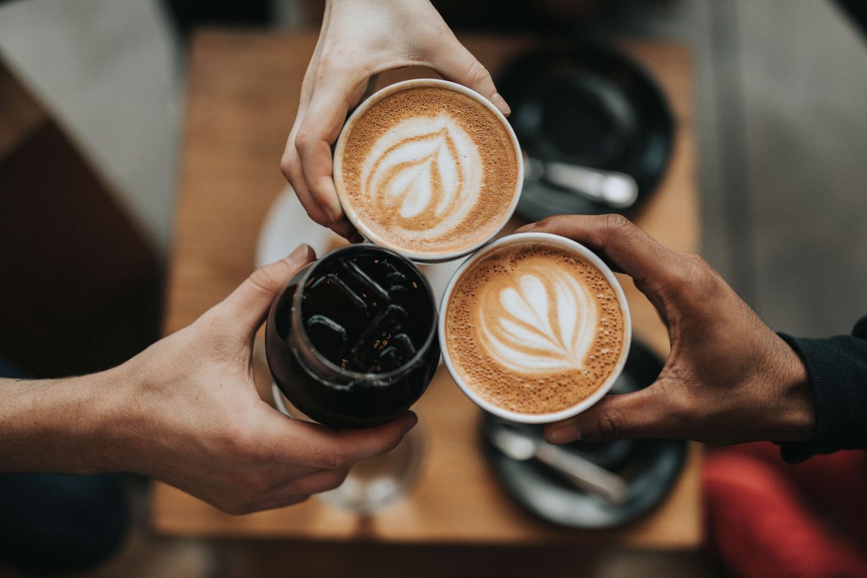 three people holding different cups of coffee.
