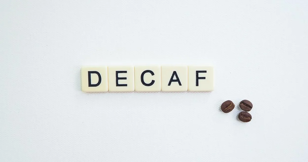 The word DECAF spelled out in white tiles.