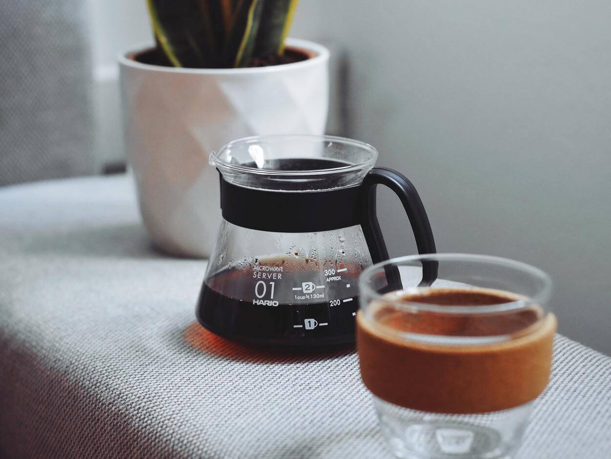 Coffee kettle and coffee mug over a table.