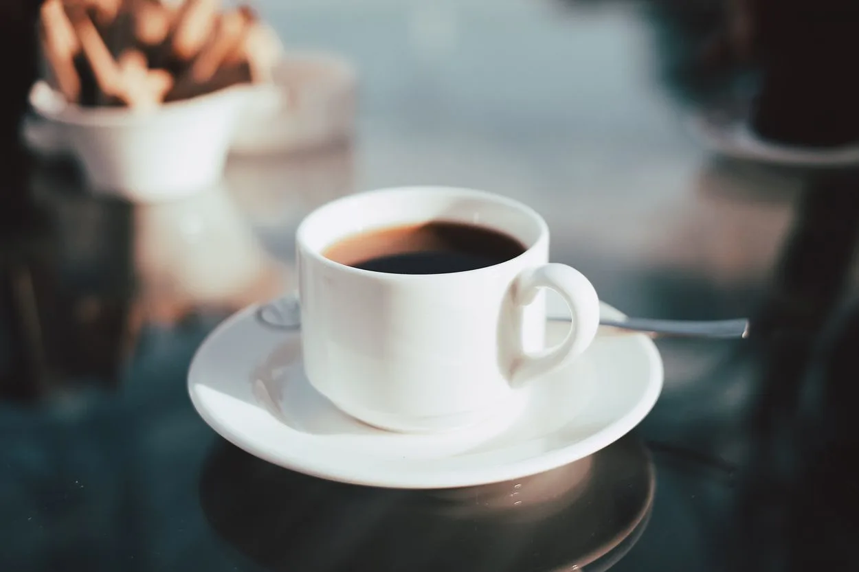 black coffee on a small white saucer