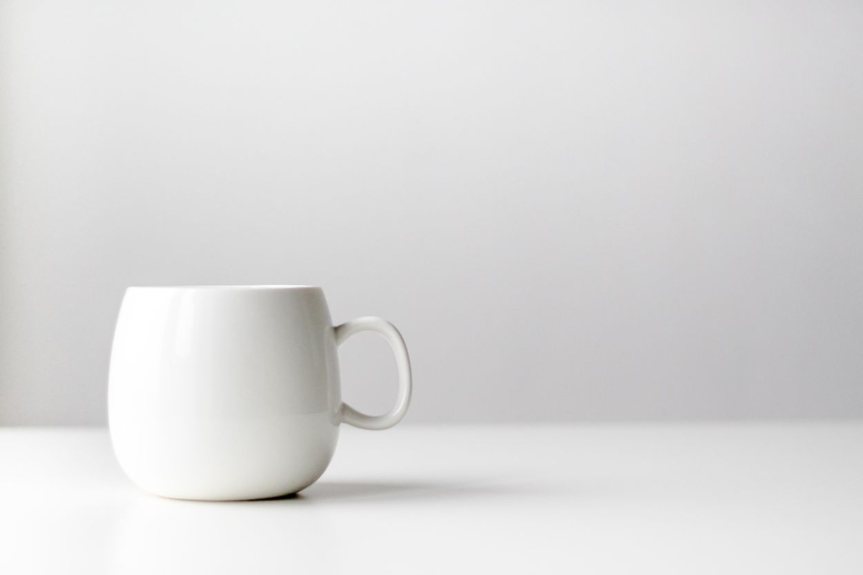 a white cup on a white table.