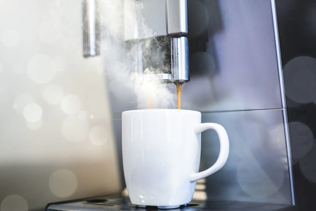 white mug under a coffee machine