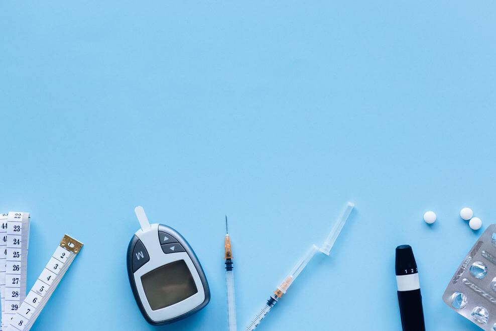 A tape measure, blood sugar monitor, pills and a needle.