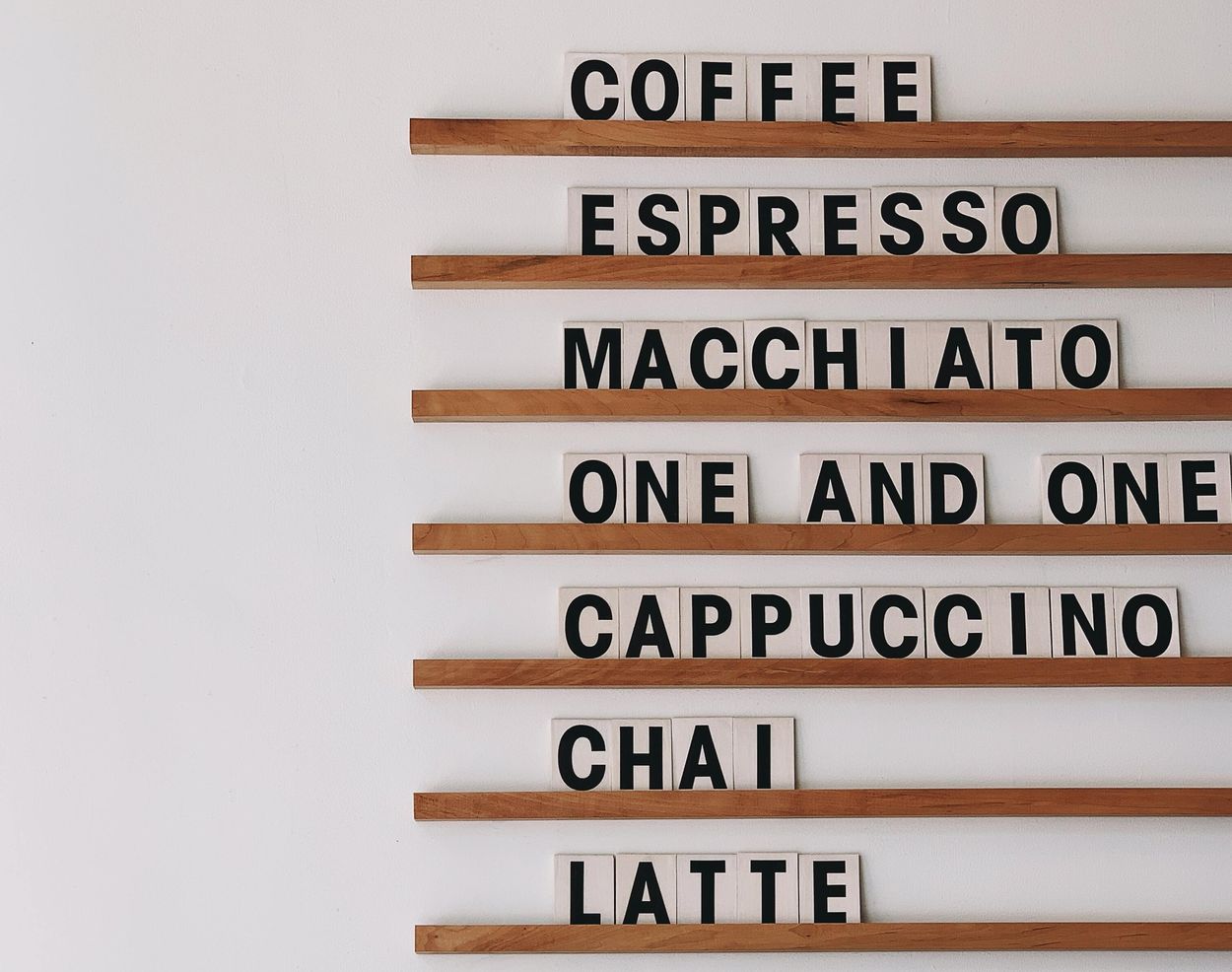 a shelf with the words of different types of coffee on them.