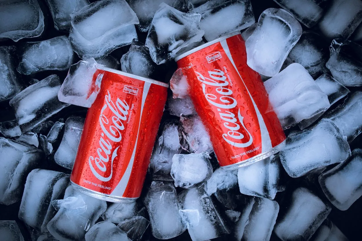 two cans of Coca-Cola in ice
