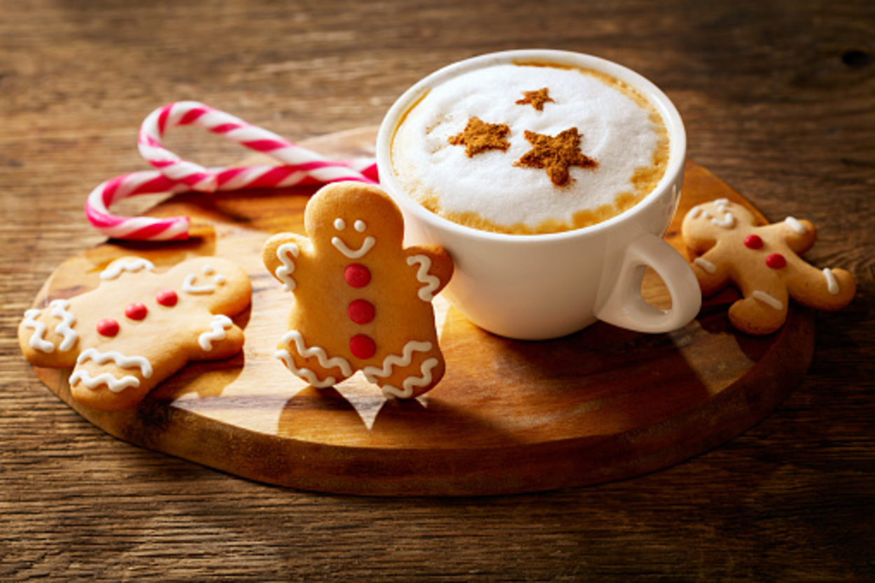 A cup of cappuccino with gingerbread on a wooden table
