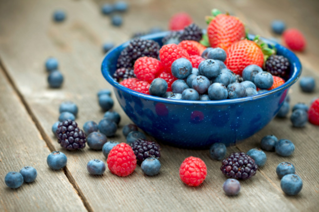 "A bowlful of delicious organic berries.  Strawberries, blackberries, blueberries, and raspberries.  
