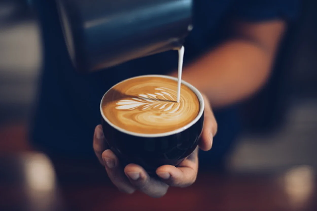 Barista making latte art on cappuccino