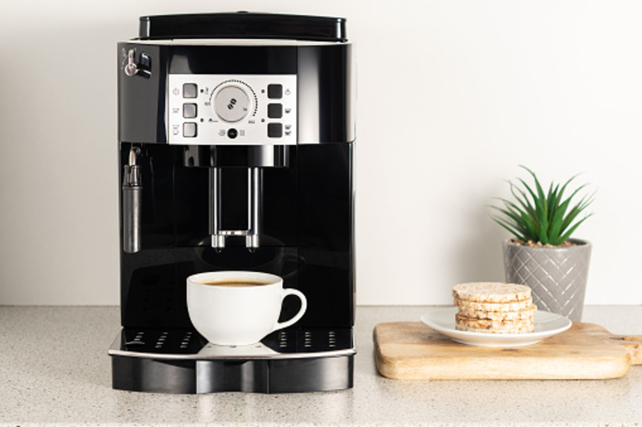 Modern espresso coffee machine with a cup in the interior of kitchen closeup.