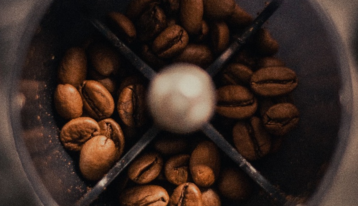 Image of coffee beans being grinded in a coffee grinder.
